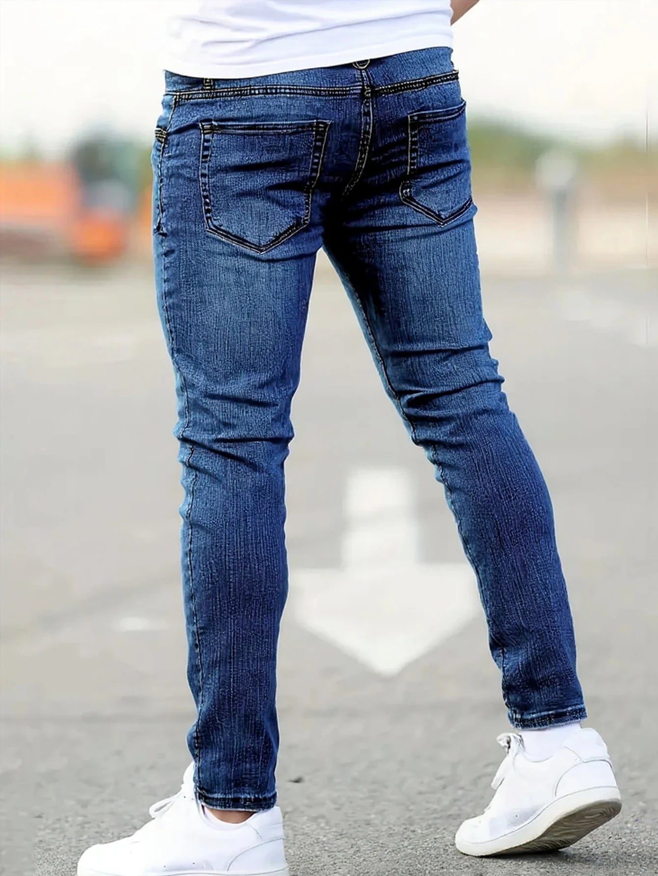 Men's slim-fit blue jeans with subtle distressing, contouring to the body, effortlessly creating a casual and trendy style.